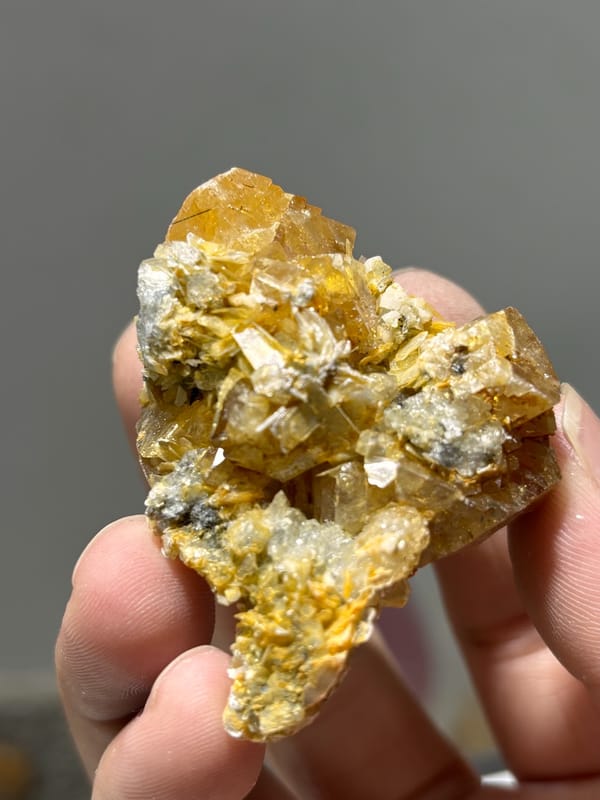 Orange scheelite with aquamarine and mica from Xuebaoding, Sichuan, China, close-up of the crystal faces