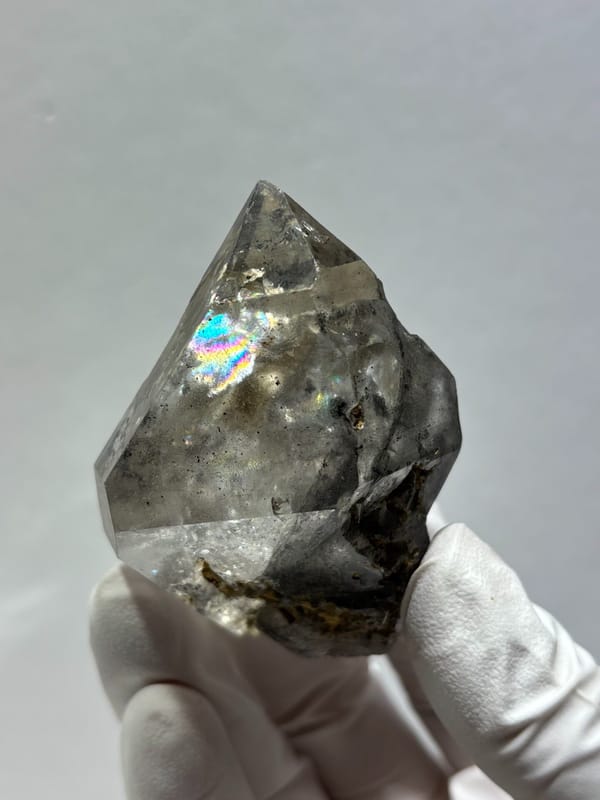 Clay skeletal quartz floater with rainbow flashes from Guizhou, China, close-up of the crystal faces