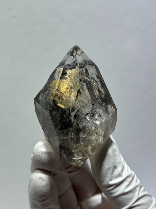 Clay skeletal quartz floater with rainbow flashes from Guizhou, China, detail of the matrix contact
