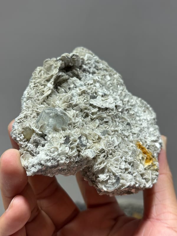 Plate of silvery mica rosettes with aquamarine and scheelite from Xuebaoding, Sichuan, China, close-up of the crystal faces