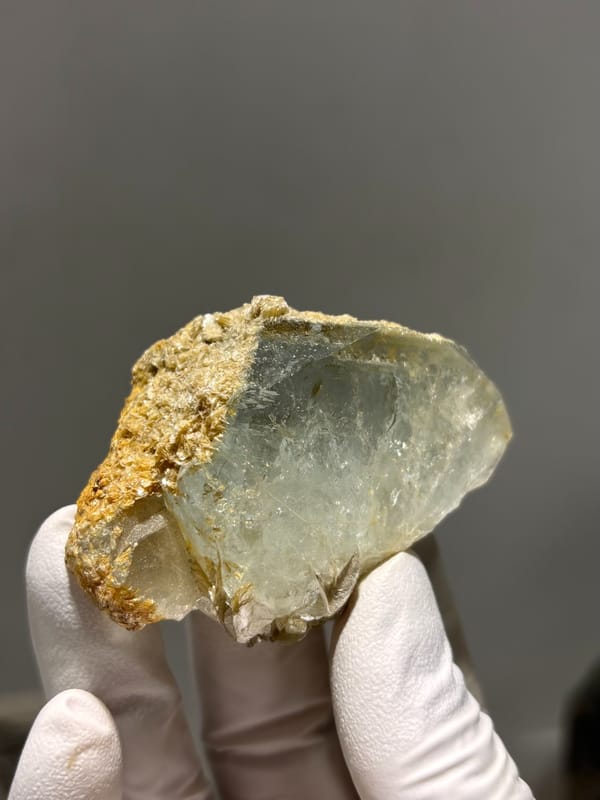 Flat pale green aquamarine with golden mica rim from Xuebaoding, Sichuan, China, close-up of the crystal faces