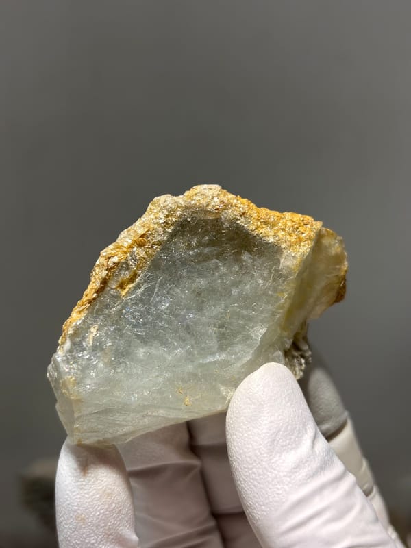 Flat pale green aquamarine with golden mica rim from Xuebaoding, Sichuan, China, reverse side