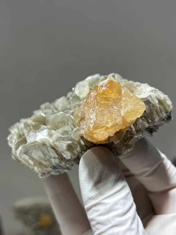 Mica plate with honey scheelite crystal from Xuebaoding, Sichuan, China, close-up of the crystal faces