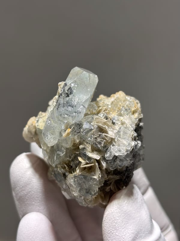 Pale blue aquamarine over white mica and feldspar from Xuebaoding, Sichuan, China, reverse side
