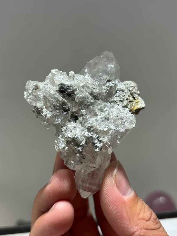 Clear quartz cluster with mica and dark flecks from Xuebaoding, Sichuan, China, reverse side