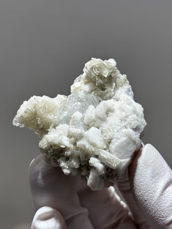 White feldspar cluster with aquamarine, mica and quartz from Xuebaoding, Sichuan, China, close-up of the crystal faces