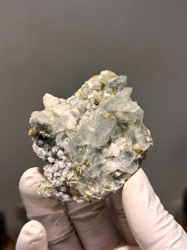 Pale aquamarine cluster over white feldspar and mica from Xuebaoding, Sichuan, China, reverse side