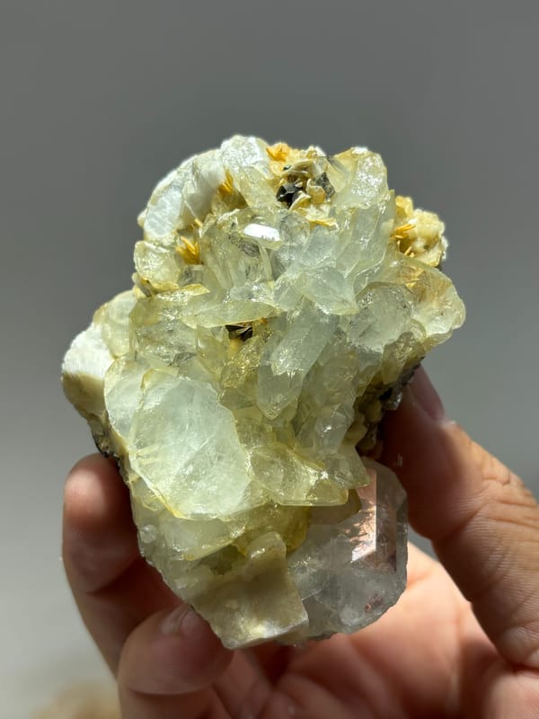 Yellow-green aquamarine crystals with cassiterite and feldspar from Xuebaoding, Sichuan, China, close-up of the crystal faces