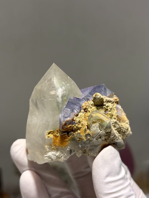 Clear quartz point with purple fluorite cube from Yaogangxian, Hunan, China, close-up of the crystal faces