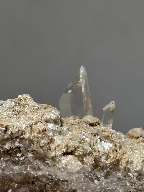Grey matrix plate with small quartz prism and mica from Xuebaoding, Sichuan, China, reverse side