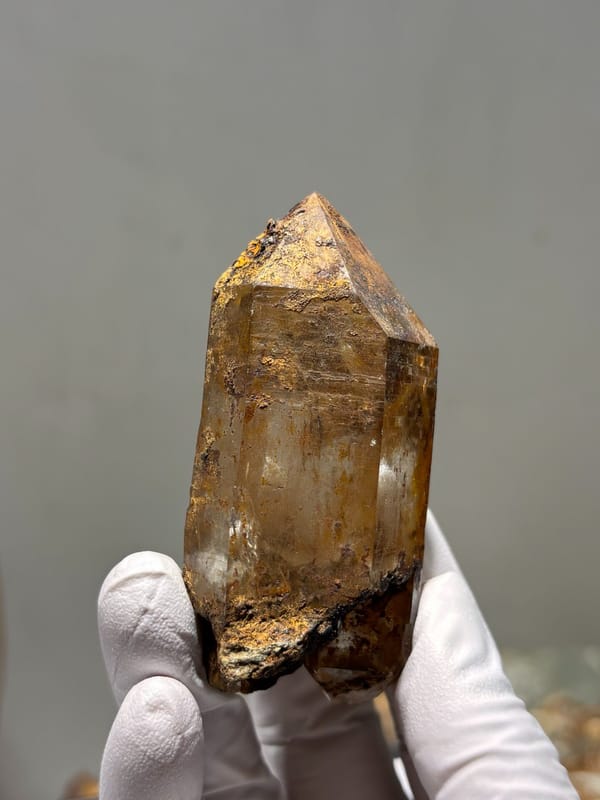 Himalayan quartz with rusty coat and complete tip, close-up of the crystal faces