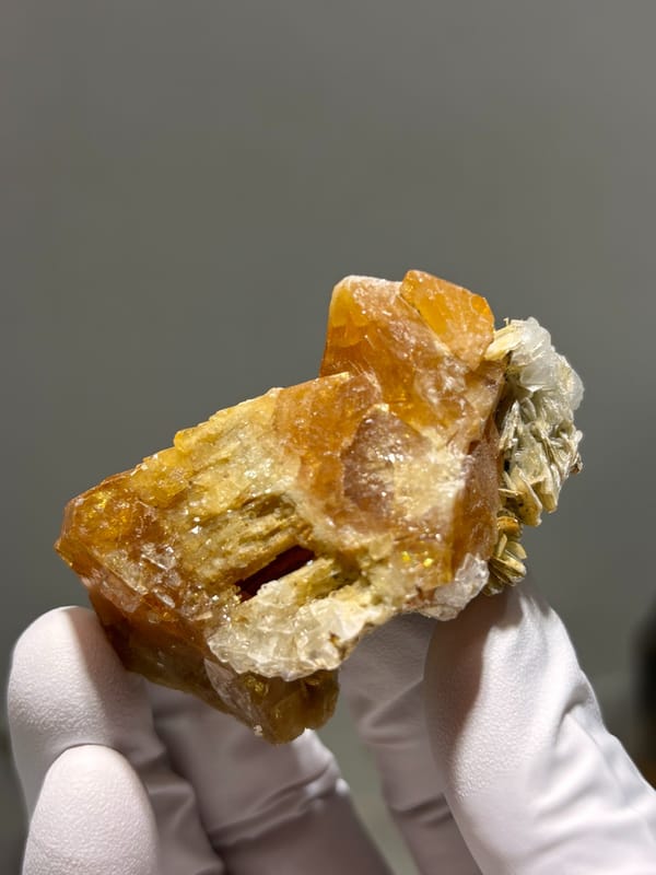 Orange scheelite floater from Xuebaoding, Sichuan, China, close-up of the crystal faces