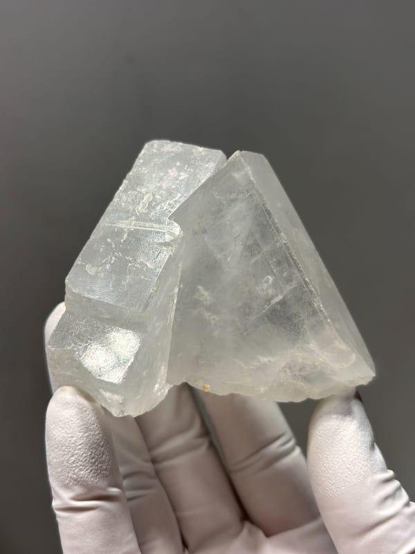 Clear baryte crystal group from Jinkouhe, Sichuan, China, held in gloved hand