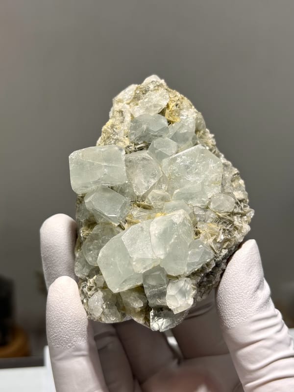 Pale aquamarine prisms lying on grey mica from Xuebaoding, Sichuan, China, reverse side