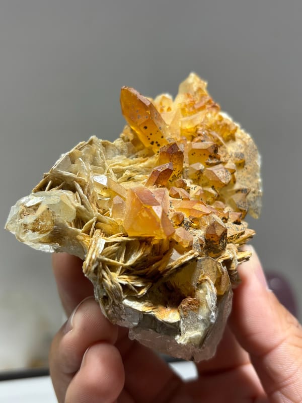 Golden-stained quartz on mica with aquamarine from Xuebaoding, Sichuan, China, close-up of the crystal faces
