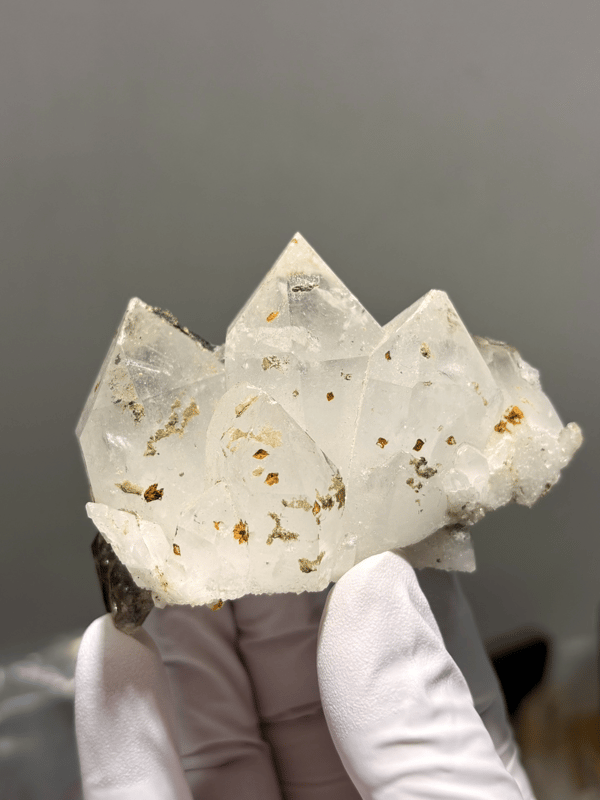 Milky Tibetan quartz cluster with imprint marks from Tibet, China, held in gloved hand