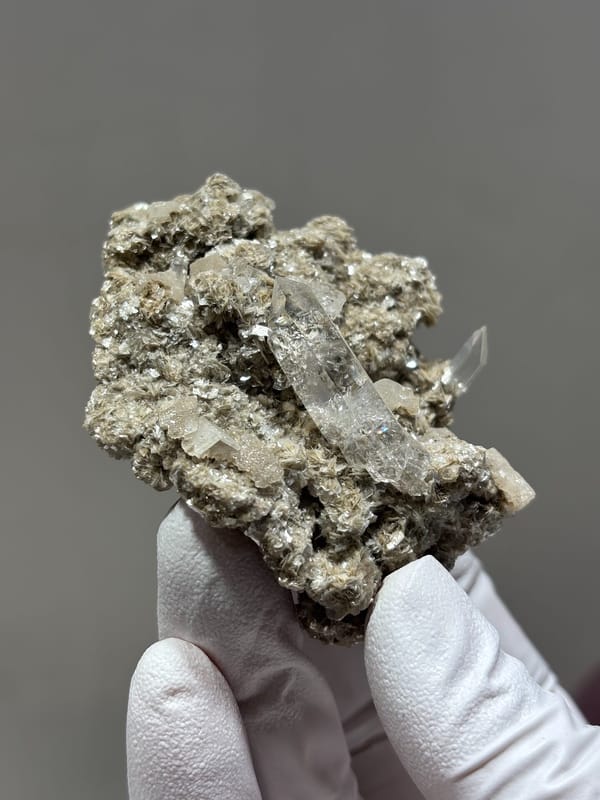 Clear quartz point in mica and calcite matrix from Xuebaoding, Sichuan, China, close-up of the crystal faces