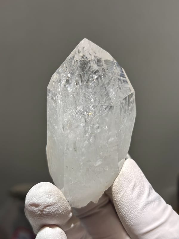 Icy clear quartz point with rainbow flash from Jinkouhe, Sichuan, China, detail of the matrix contact
