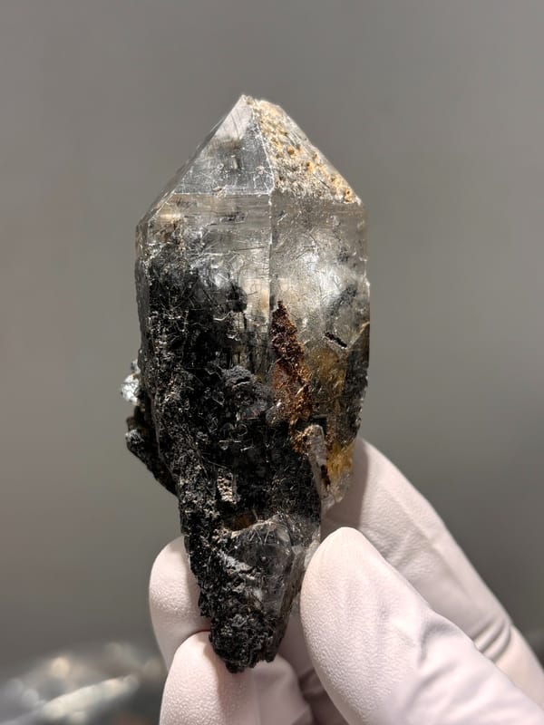Smoky quartz point with black rutile on dark base from Xuebaoding, Sichuan, China, reverse side