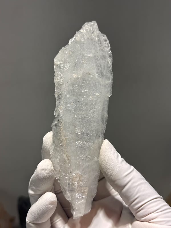 Flat tabular quartz blade from Jinkouhe, Sichuan, China, held in gloved hand