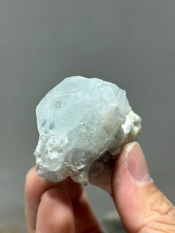Pale blue aquamarine on white feldspar and mica from Xuebaoding, Sichuan, China, close-up of the crystal faces