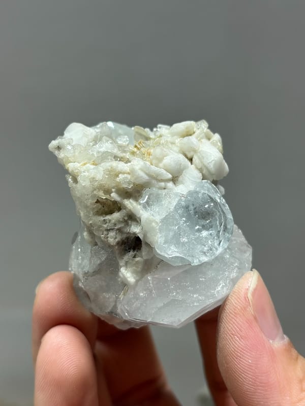 Pale blue aquamarine on white feldspar and mica from Xuebaoding, Sichuan, China, reverse side