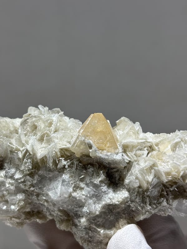 Mica plate with orange scheelite crystal from Xuebaoding, Sichuan, China, close-up of the crystal faces