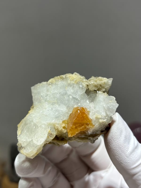 Pale aquamarine cluster with orange scheelite crystal from Xuebaoding, Sichuan, China, close-up of the crystal faces