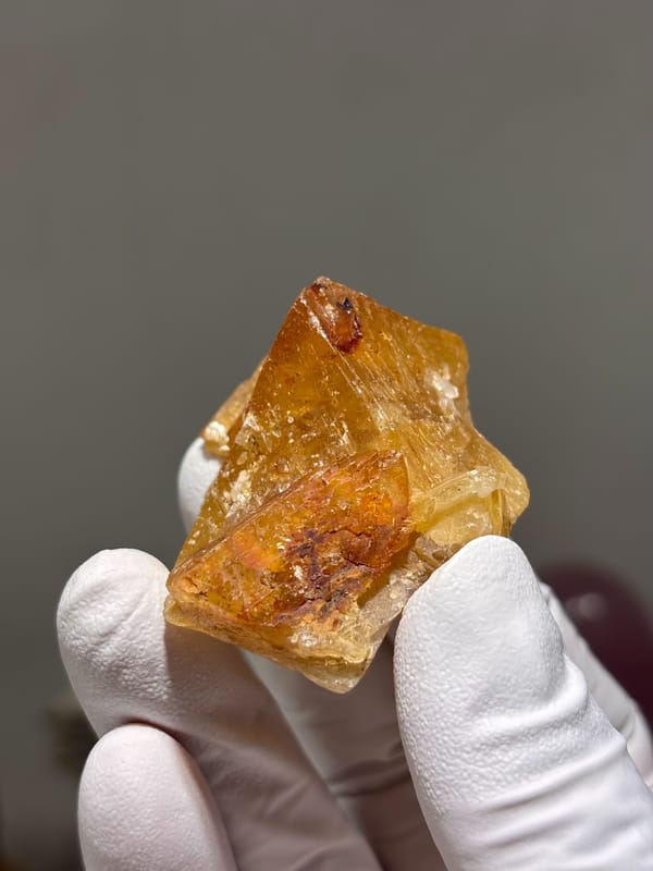 Orange scheelite crystal with glassy faces from Xuebaoding, Sichuan, China, close-up of the crystal faces