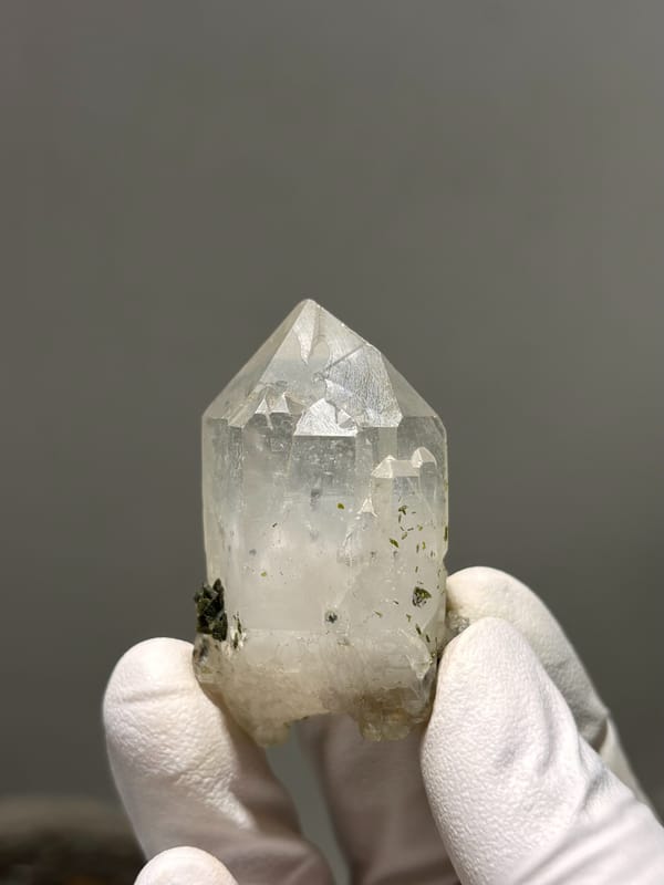 Clear garden quartz point with floater base from Sichuan, China, held in gloved hand