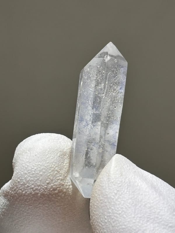 Tiny dumortierite-in-quartz double-terminated crystal from Brazil, close-up of the crystal faces