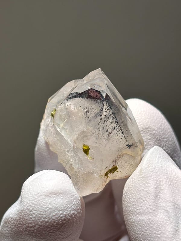 Tiny garden quartz with green epidote specks from Sichuan, China, detail of the matrix contact