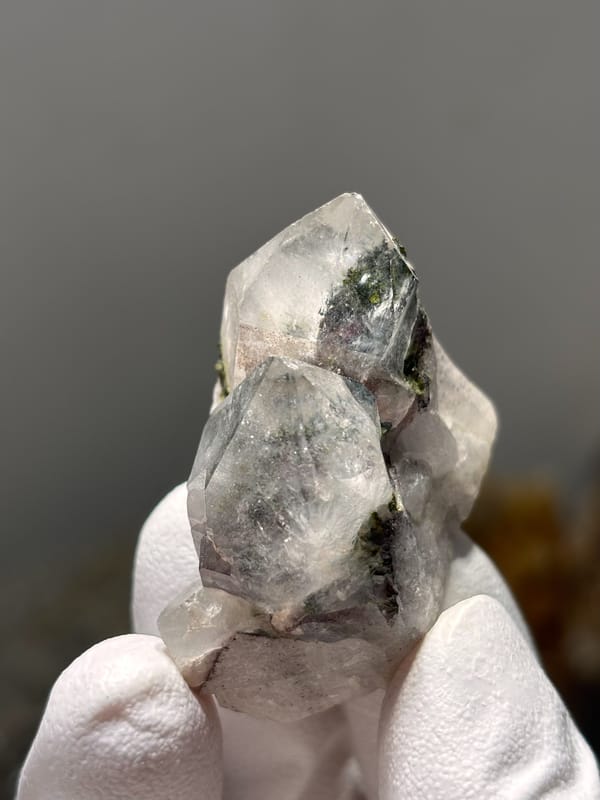 Garden quartz with green chlorite phantoms from Sichuan, China, held in gloved hand