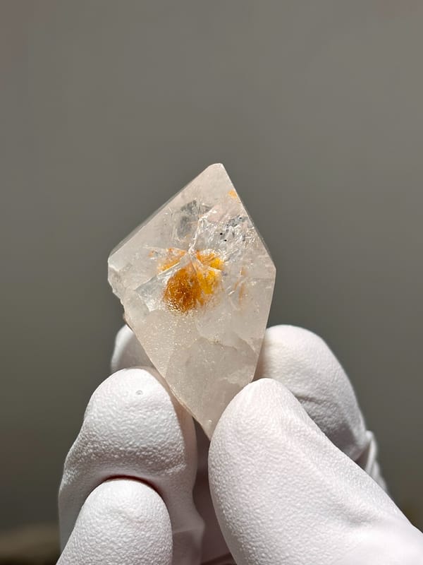 Garden quartz with bright orange inclusion from Sichuan, China, close-up of the crystal faces