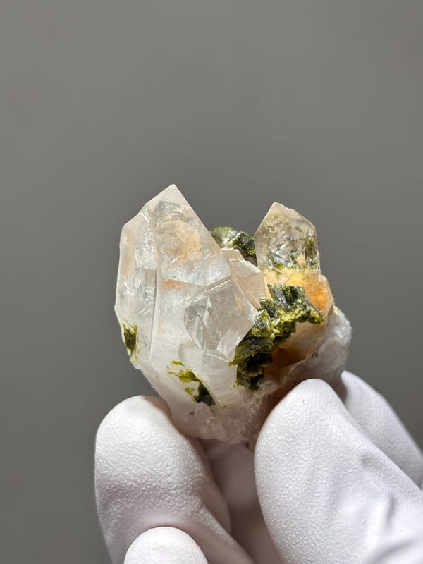 Garden quartz cluster with green and orange inclusions from Sichuan, China, close-up of the crystal faces