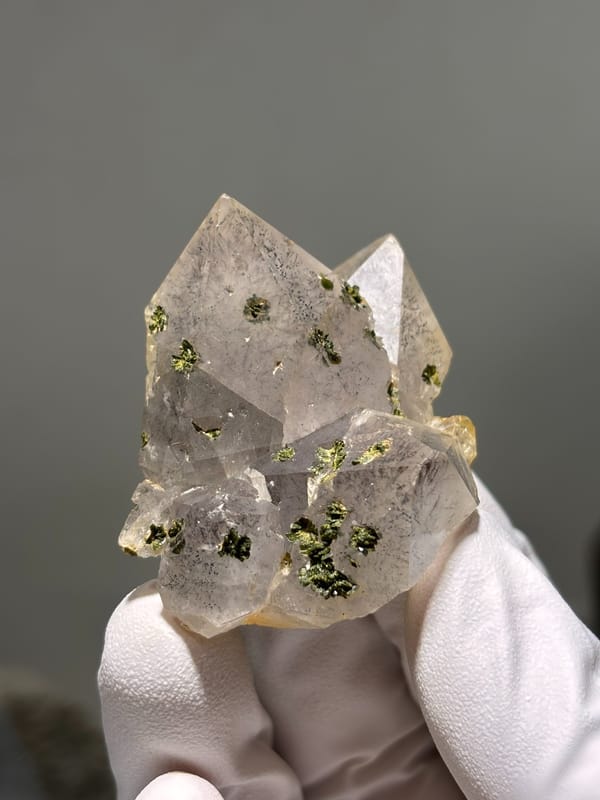 Garden quartz cluster with green epidote specks from Sichuan, China, close-up of the crystal faces