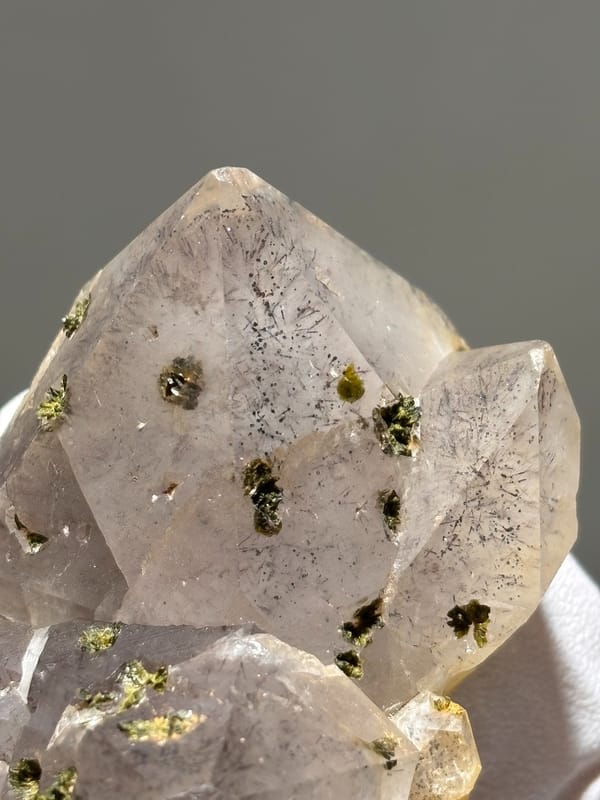 Garden quartz cluster with green epidote specks from Sichuan, China, detail of the matrix contact