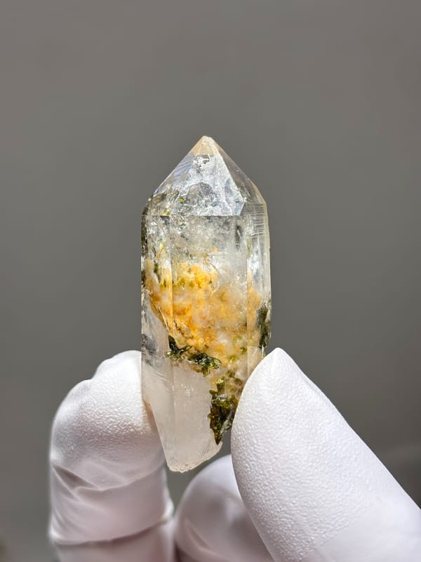 Garden quartz with orange and green inclusions from Sichuan, China, held in gloved hand