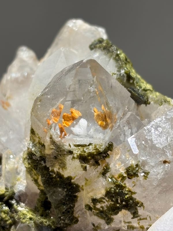 Garden quartz cluster with epidote and orange inclusions from Sichuan, China, close-up