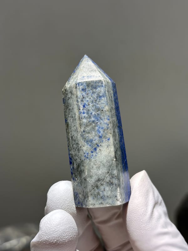 Polished lapis lazuli point with pyrite flecks from Afghanistan, close-up of the crystal faces