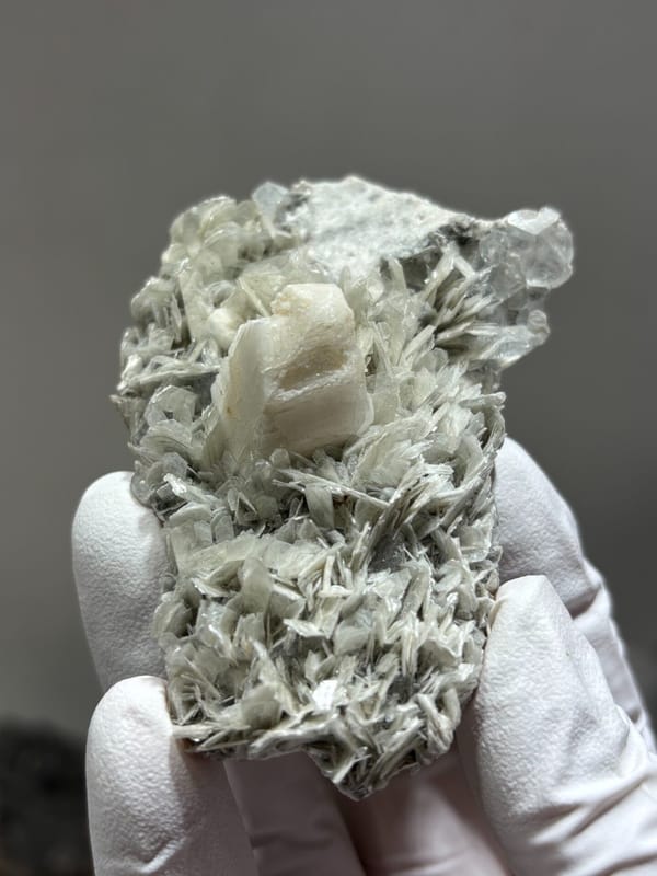 Pale mica plate with feldspar and hidden aquamarine from Xuebaoding, Sichuan, China, detail of the matrix contact