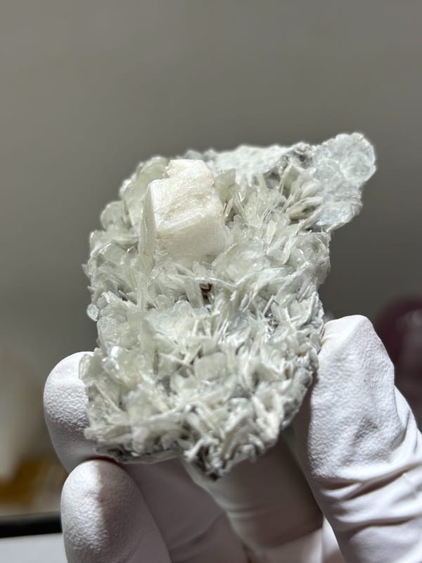 Pale mica plate with feldspar and hidden aquamarine from Xuebaoding, Sichuan, China, side view