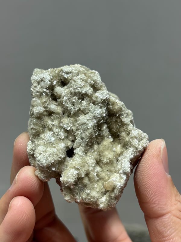 Silvery mica block with small quartz prism and white calcite from Xuebaoding, Sichuan, China, top view