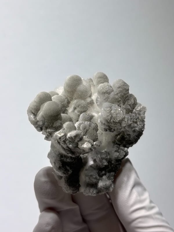 Grey botryoidal hydrozincite cluster from Yunnan, China, close-up of the crystal faces