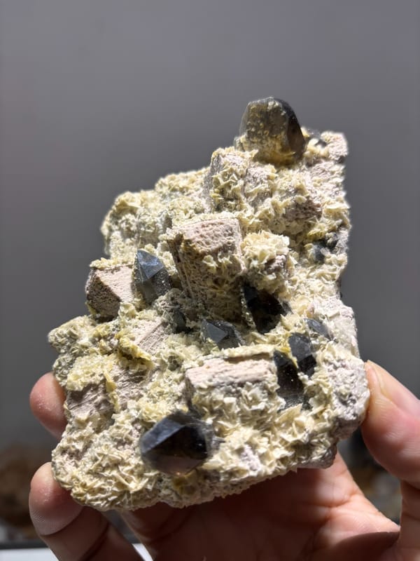 Feldspar plate with smoky quartz and calcite from Fujian, China, close-up of the crystal faces