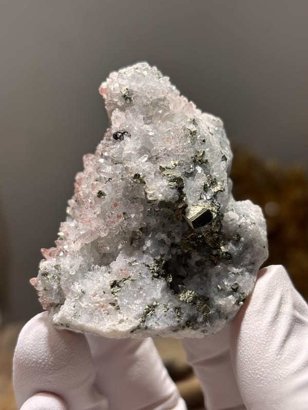 Pink-skinned quartz druse with pyrite from Jiangxi, China, close-up of the crystal faces