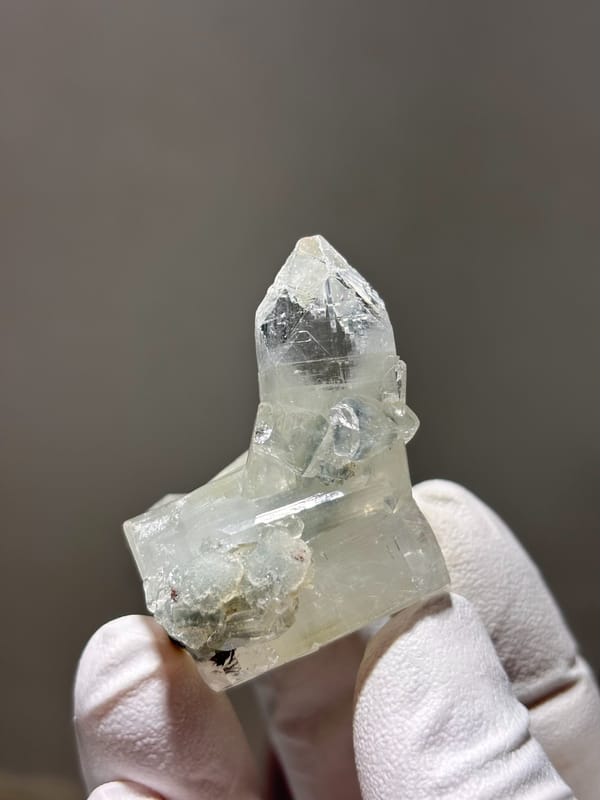 Clear apophyllite pyramid on white cluster from India, close-up of the crystal faces