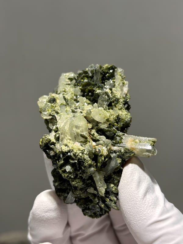 Dark green epidote cluster with white quartz points from Sichuan, China, close-up of the crystal faces