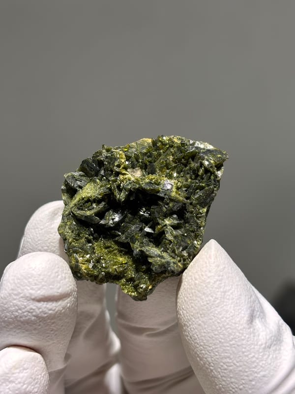Dark green epidote crystal cluster from Sichuan, China, close-up of the crystal faces