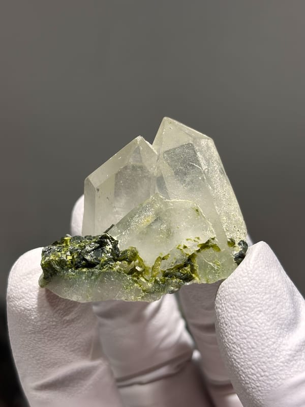 Two clear quartz points with green epidote from Sichuan, China, close-up of the crystal faces